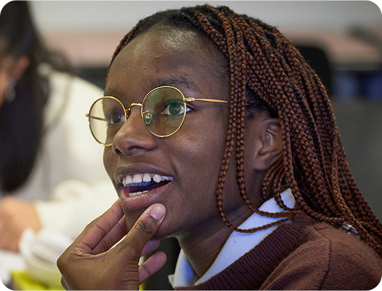 Student in IB classroom visually engaged in class discussion.