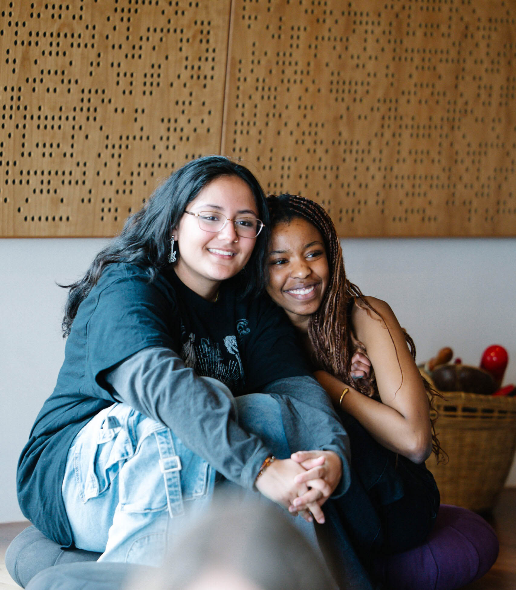 Two diverse UWC-USA students share a warm moment, reflecting community and belonging in the vibrant campus environment.
