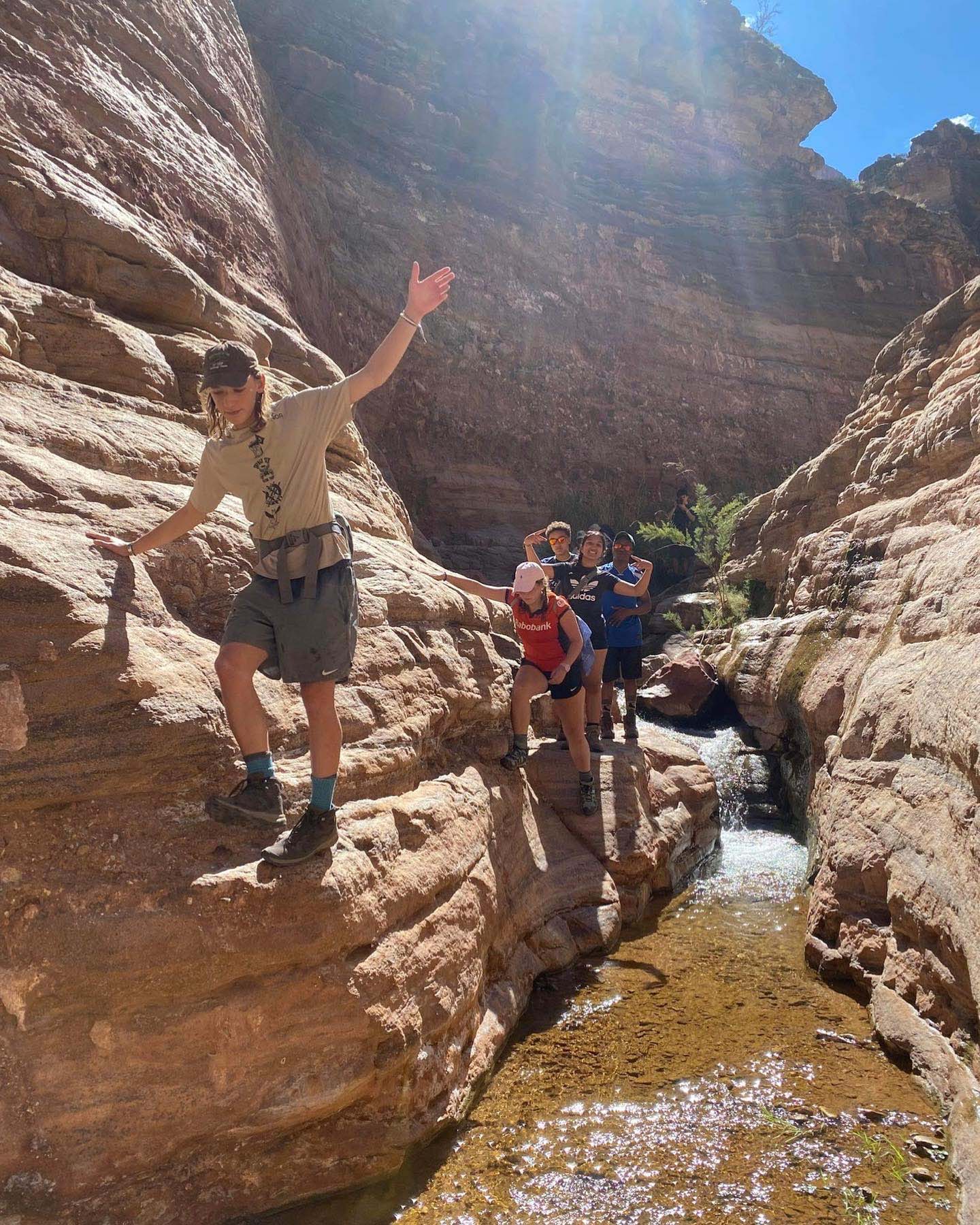 UWC-USA students from diverse backgrounds support each other on a wilderness hike, fostering teamwork and global community.