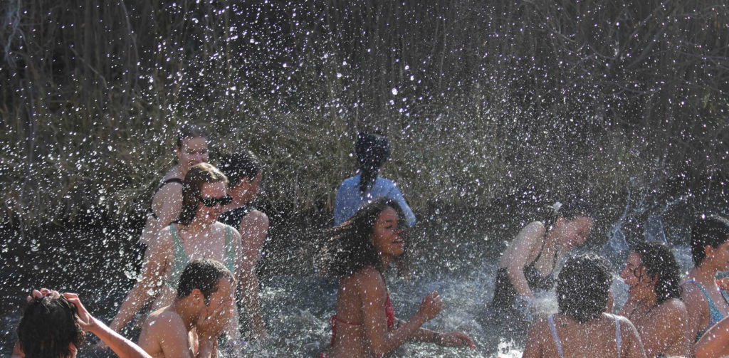 Students from diverse backgrounds enjoy a sunny team-building activity in nature, reflecting UWC-USA’s global community spirit.