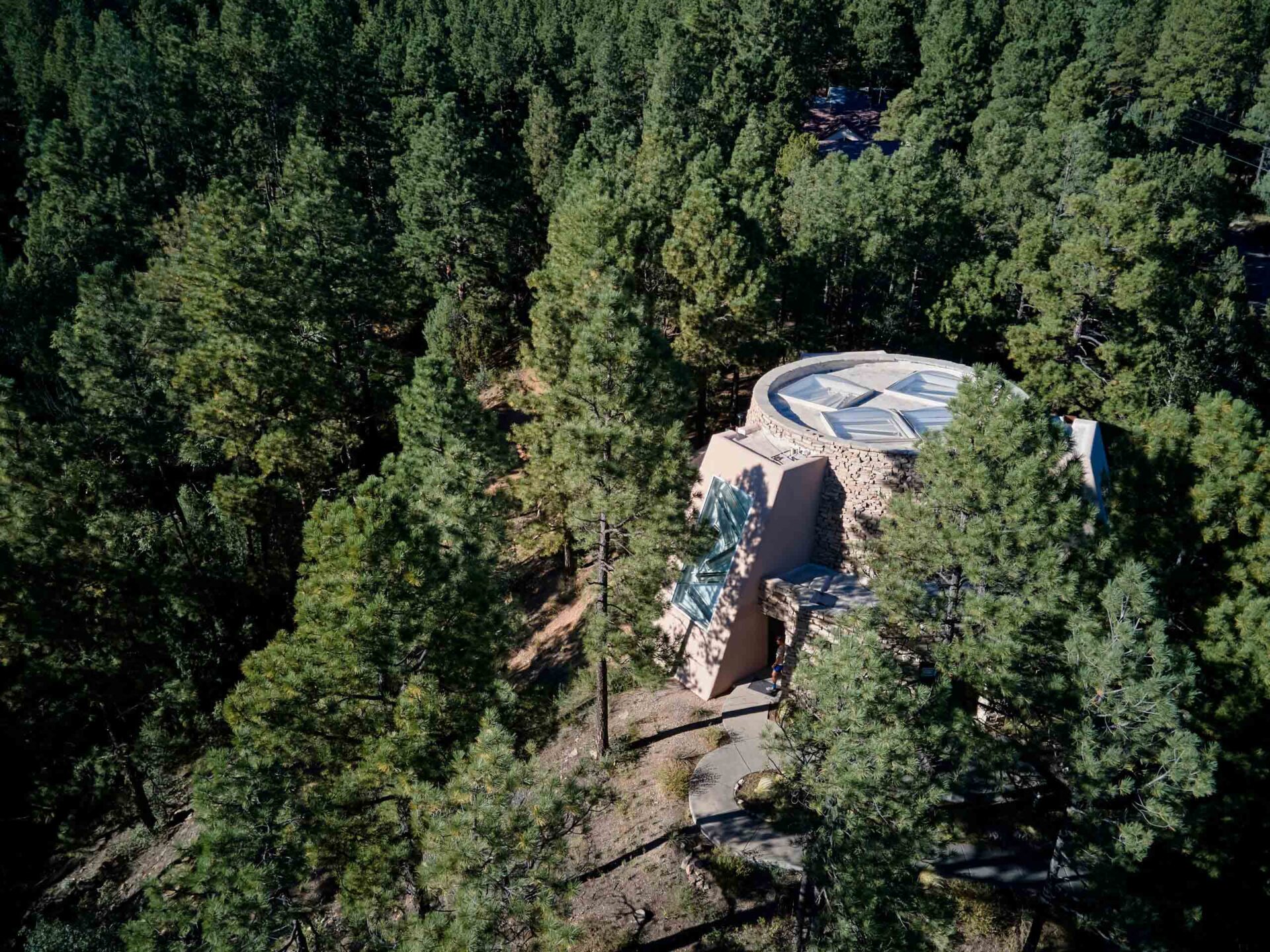 The Dwan Light Sanctuary with geometric roof set in pine forest, reflecting UWC-USA’s focus on sustainability and community.