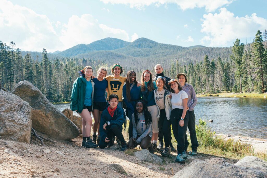 Twelve diverse UWC-USA students in hiking gear explore New Mexico wilderness, uniting for IB learning and global community.