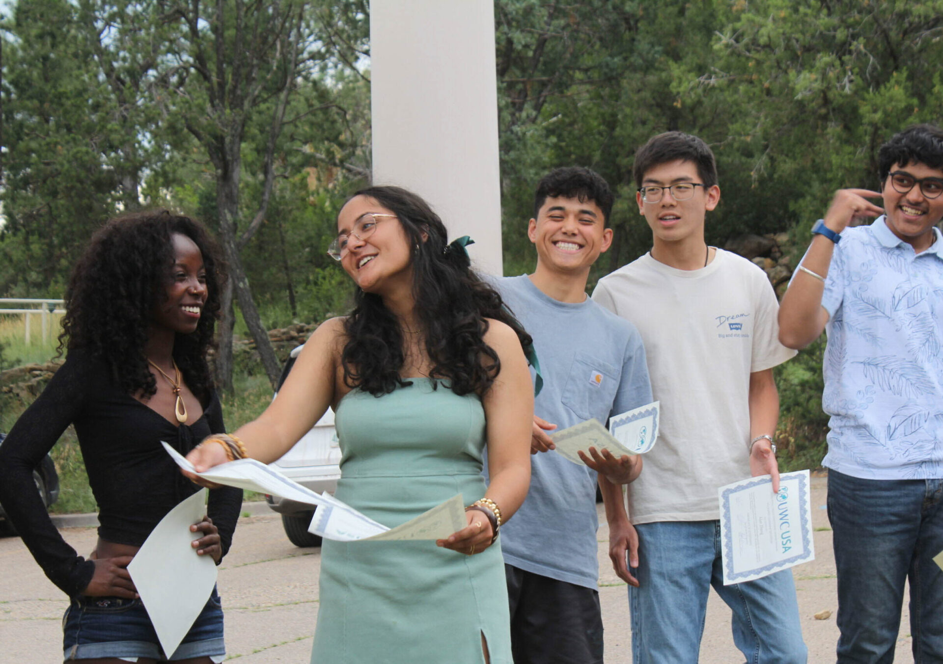 Diverse UWC-USA students celebrate wilderness achievement outdoors, highlighting global community and commitment to service.