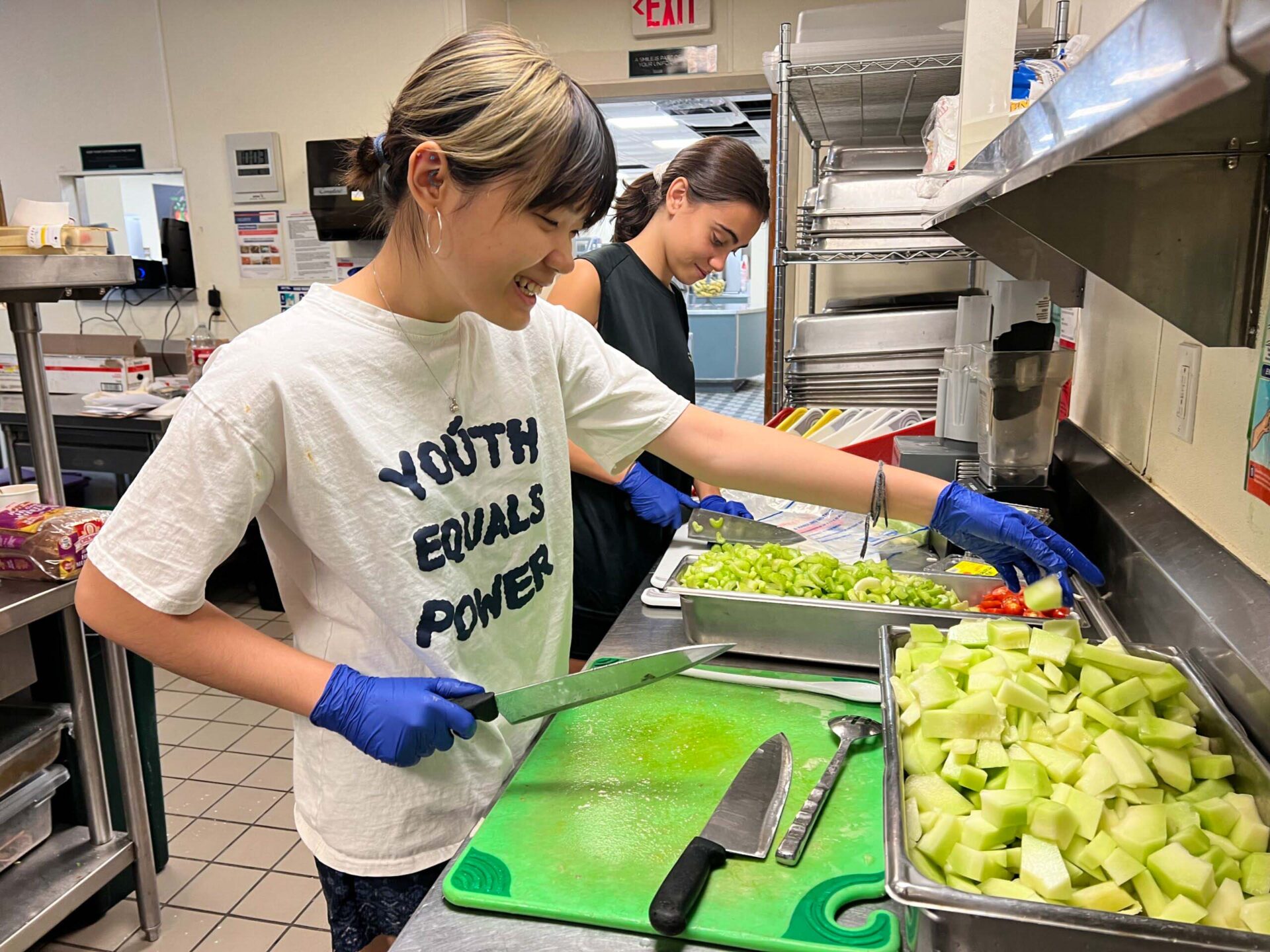Students from diverse backgrounds collaborate in UWC-USA’s kitchen, embracing campus service and sustainability through healthy meal prep.