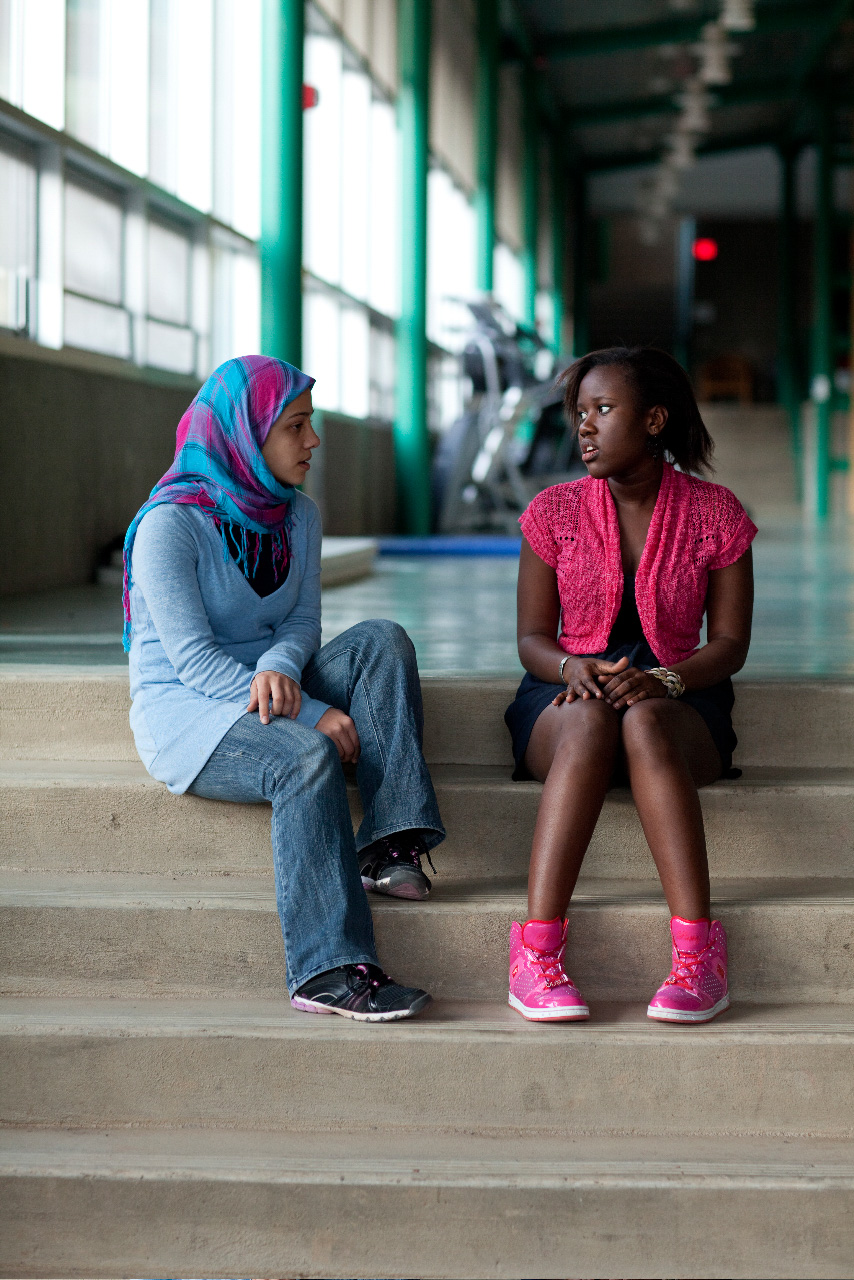 Two diverse UWC-USA students connect in the Edith Lansing Field House, reflecting a welcoming global community and vibrant academic life.