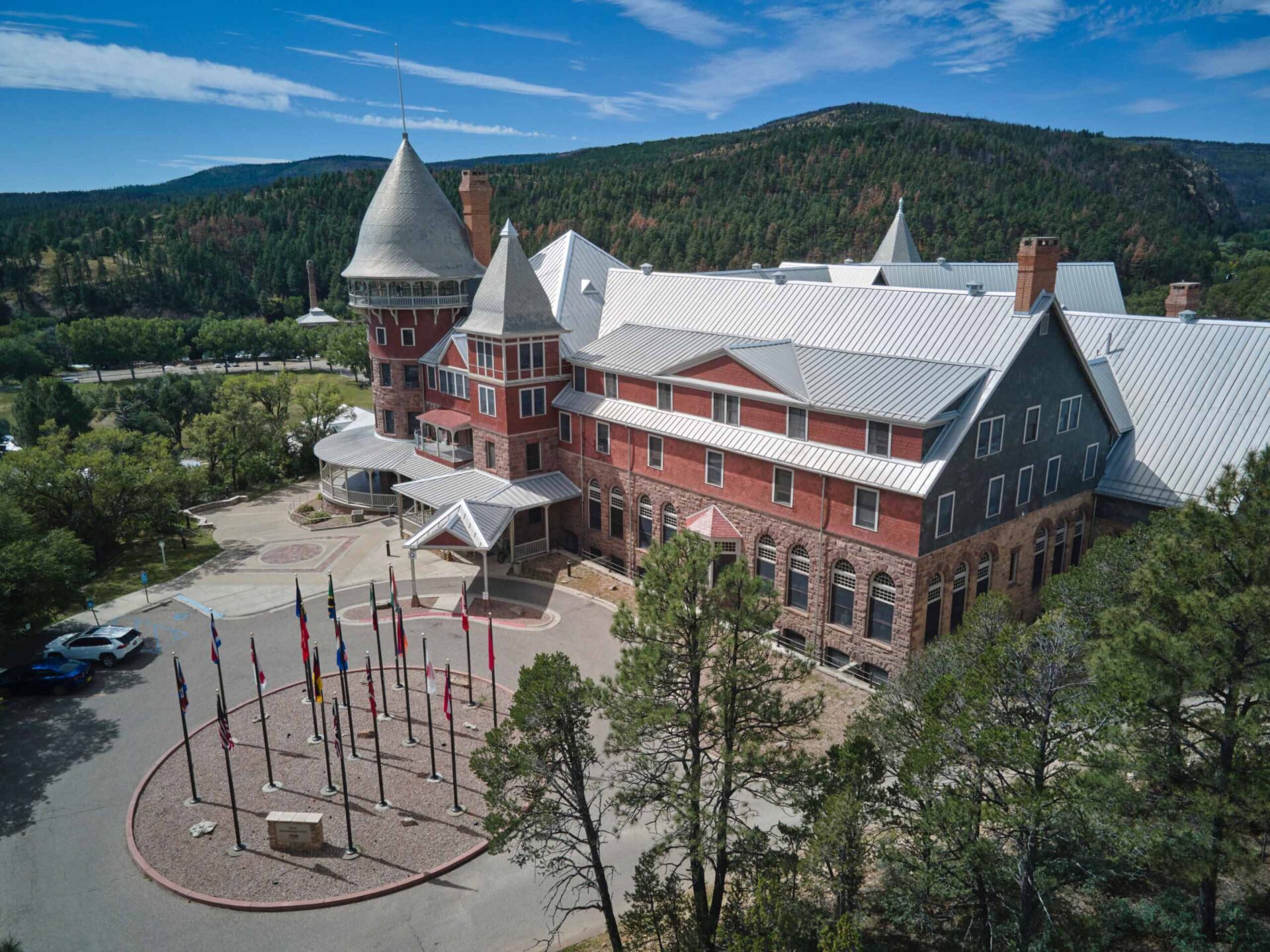 Historic Montezuma Castle amid mountains, global flags at entrance reflect UWC-USA’s diverse, sustainable, IB-focused community.
