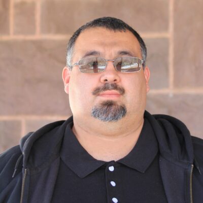 Adrian Valdez, UWC-USA community member, stands confidently against a brick wall, reflecting academic diversity and inclusion.