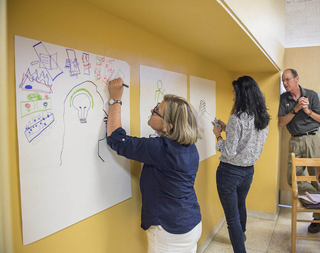 Diverse adults collaborate on creative projects during Winter IB Workshops, reflecting UWC-USA’s academic engagement and global outlook.