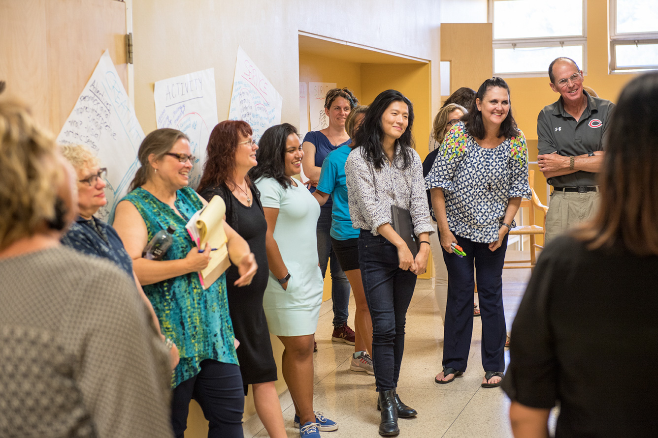 Diverse UWC-USA IB Workshop students engaging collaboratively amidst posters reflecting global learning and service.