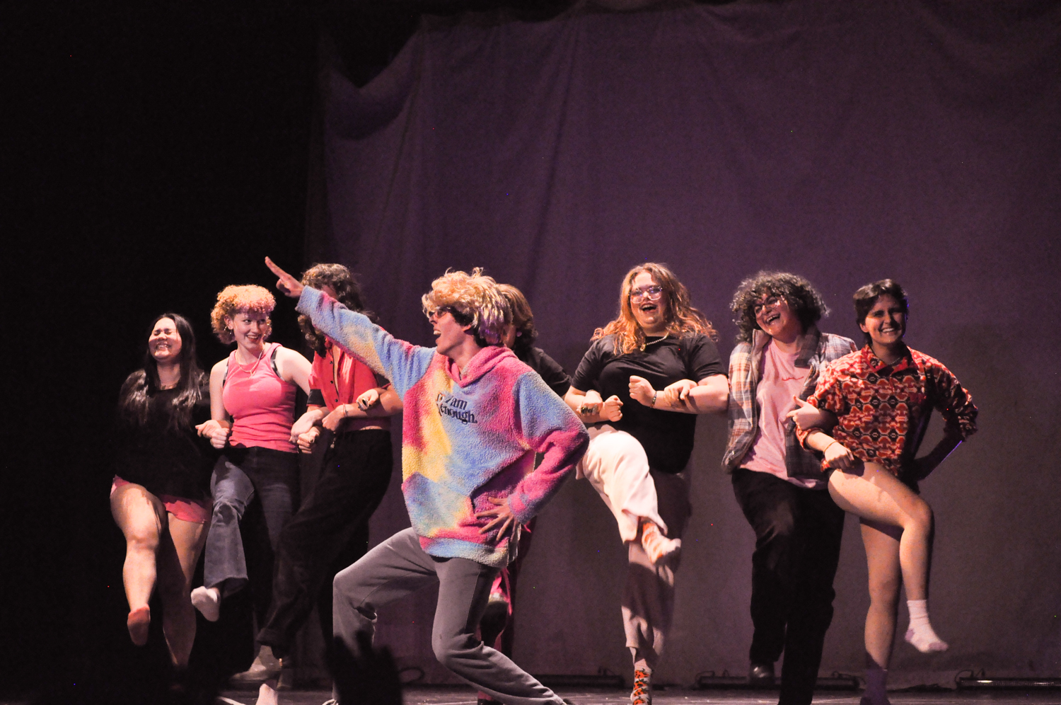 Seven diverse students perform a joyful group dance, celebrating global community and vibrant expression at UWC-USA.