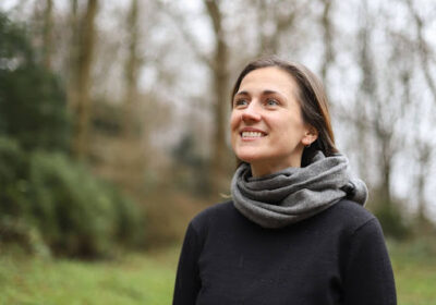 A dedicated community member smiles outdoors, reflecting UWC-USA’s commitment to service and global engagement.