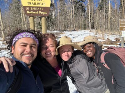 Diverse UWC-USA community members share a joyful winter moment at Winsor Trailhead, embracing outdoor learning and connection.