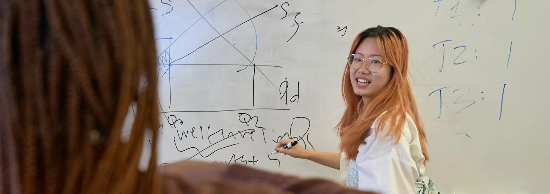 Student writing on a white board in her UWC-USA classroom.