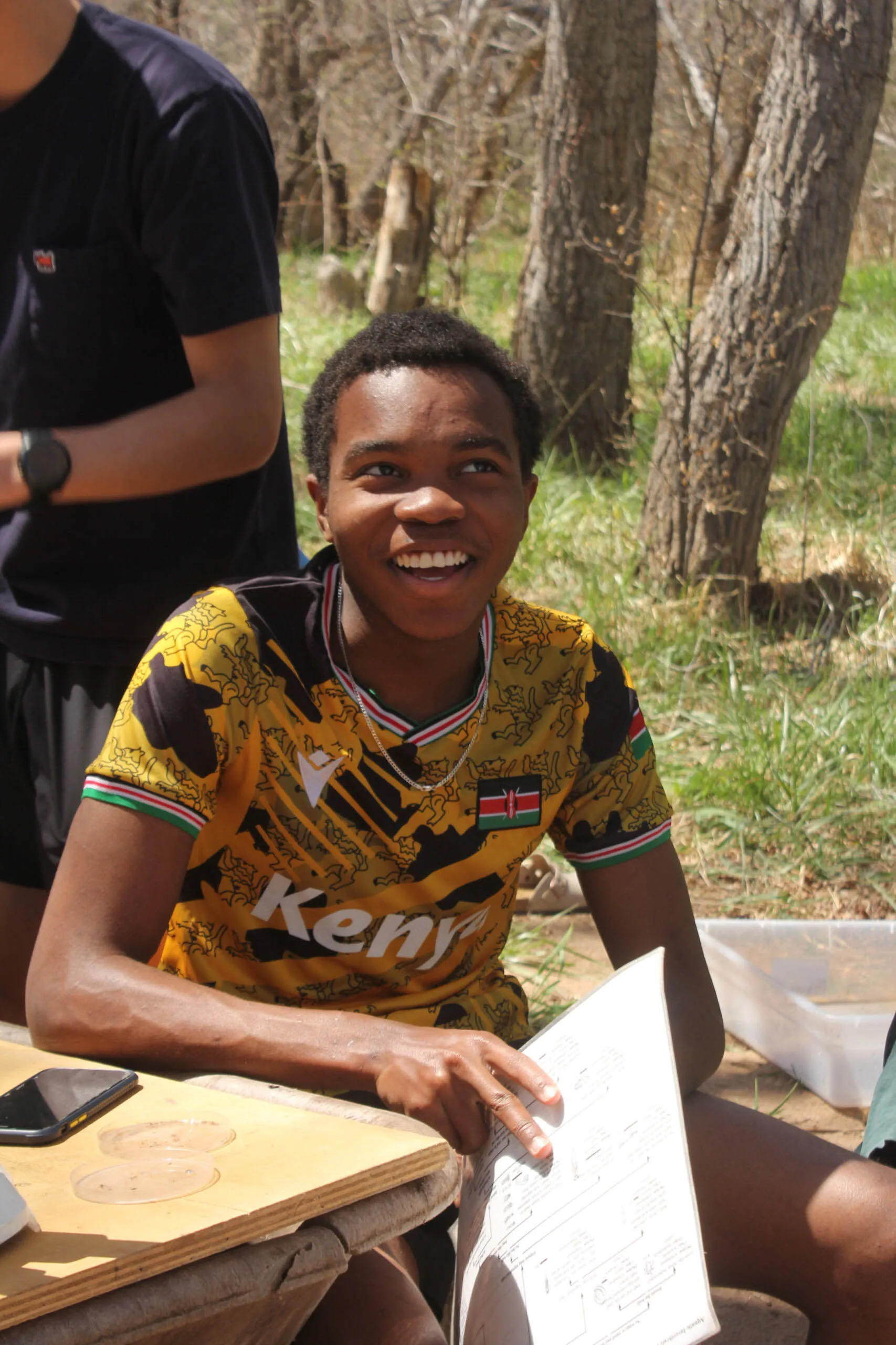 A student in a Kenya jersey engages with his peers for Environmental Systems & Societies at UWC-USA, reflecting global diversity and community learning.