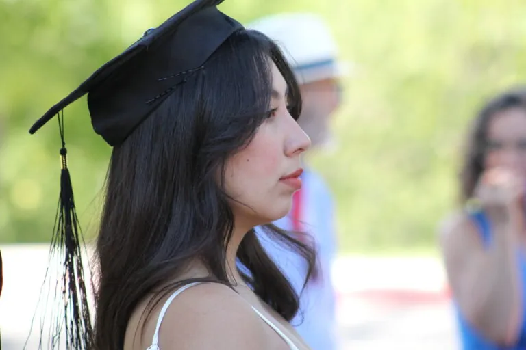 Graduating student reflects during UWC-USA commencement, highlighting academic achievement in a vibrant, global community.