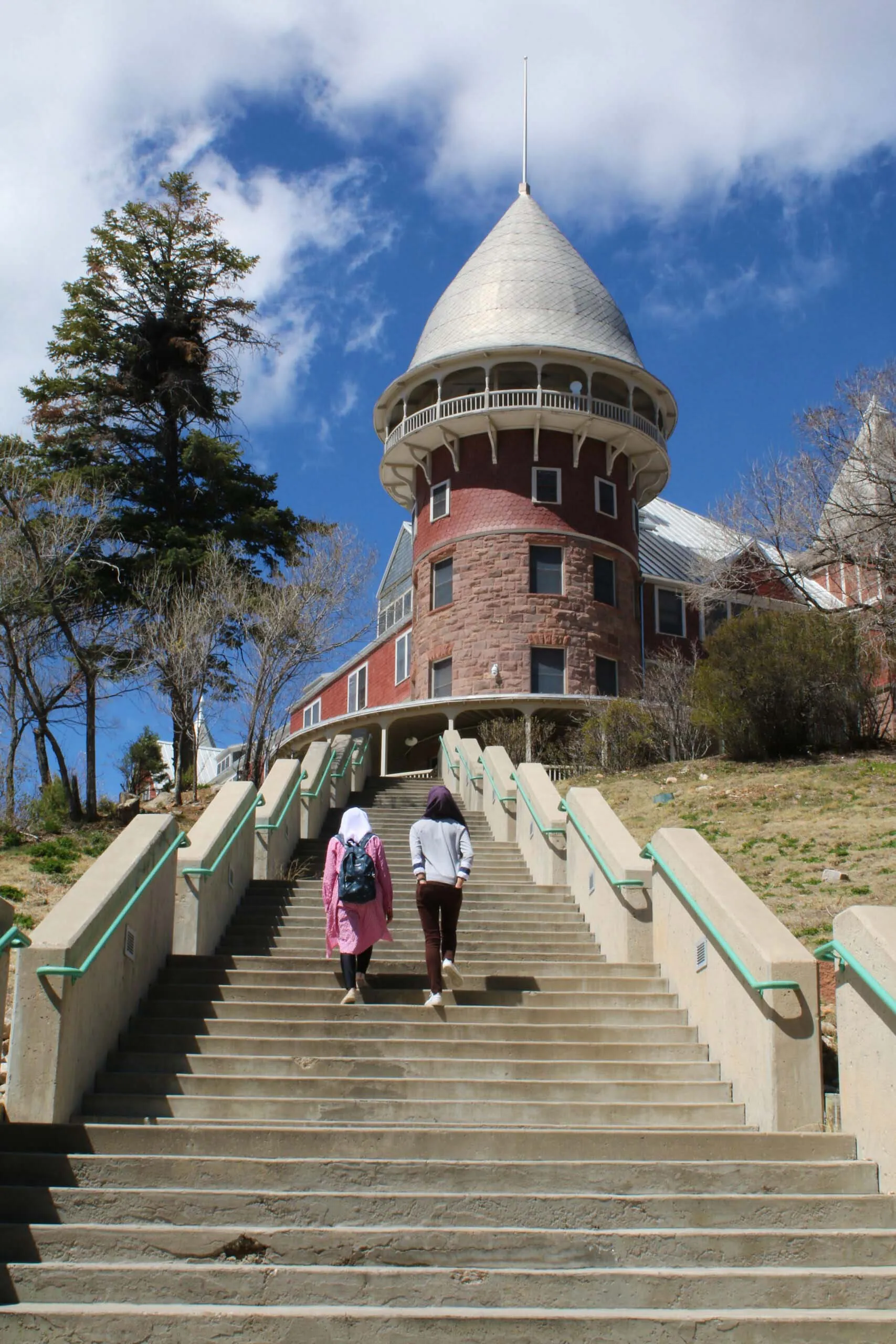 Students from diverse backgrounds approach the iconic Montezuma Castle on the UWC-USA campus, fostering global learning and community.