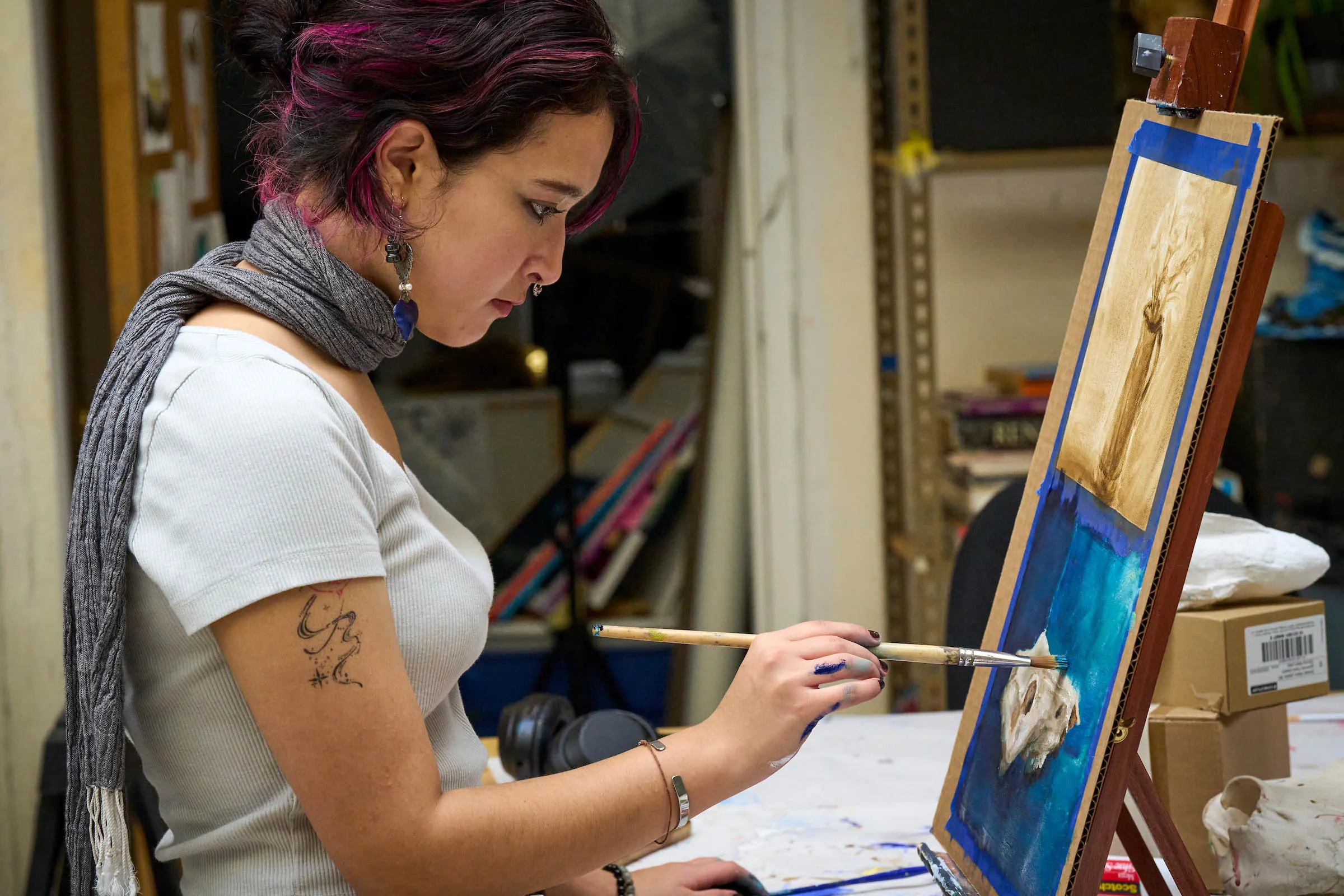 A student artist engages in creative expression in UWC-USA’s art studio, reflecting global diversity and innovative IB learning.