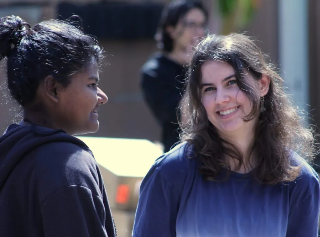 Two diverse UWC-USA students enjoy a friendly outdoor conversation, reflecting the school’s inclusive and global community.