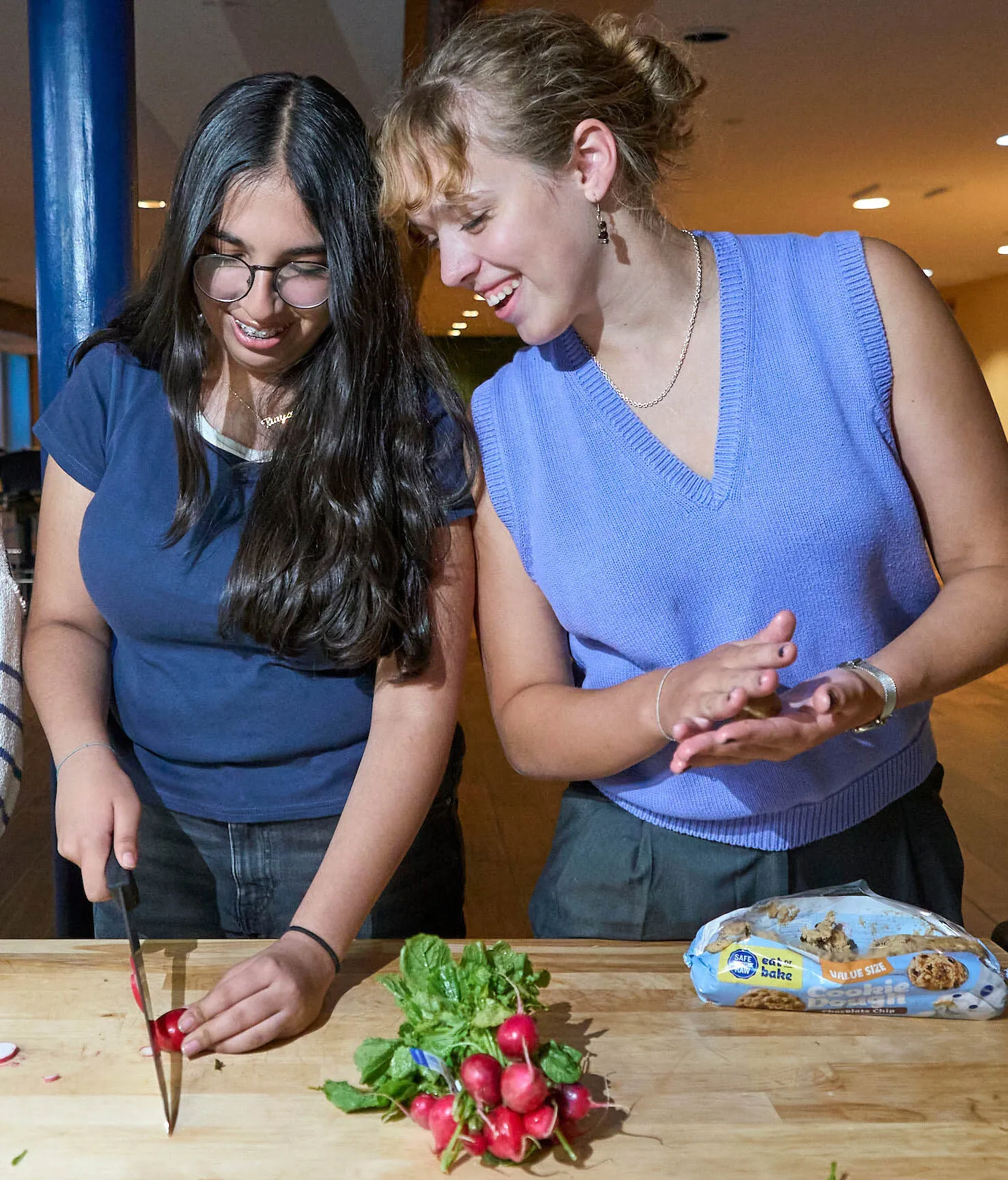 Two students collaborate in a UWC-USA kitchen, preparing healthy food together and celebrating community, service, and sustainability.